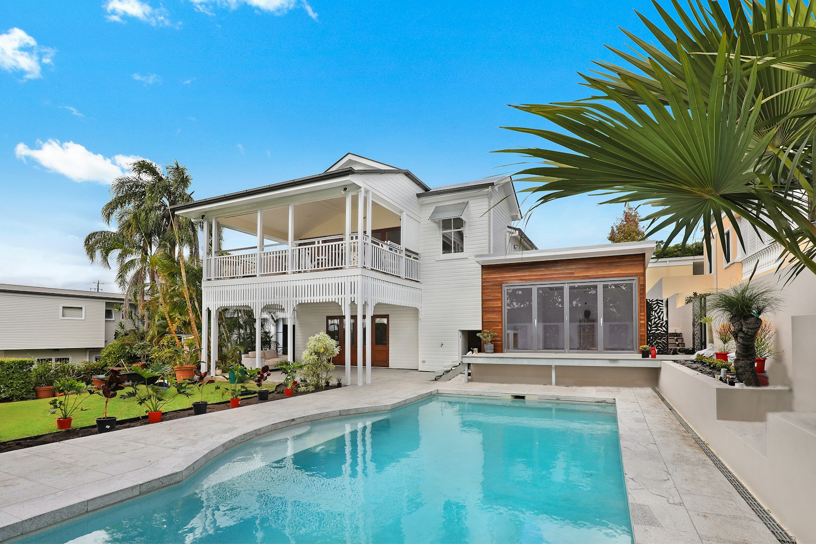 Queenslander-style home with a pool and tropical garden